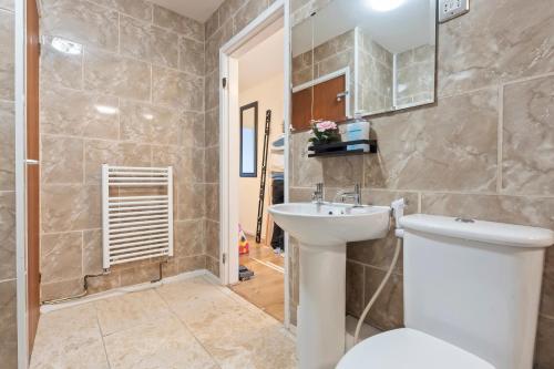 a bathroom with a toilet and a sink at Luxury 2 Bedroom Apartment with Free Parking Opposite Queen Elizabeth Hospital in Birmingham