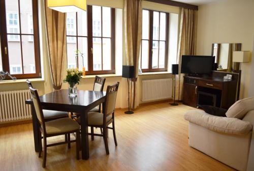 een woonkamer met een tafel en stoelen en een bank bij Apartament Dominikański in Gdańsk