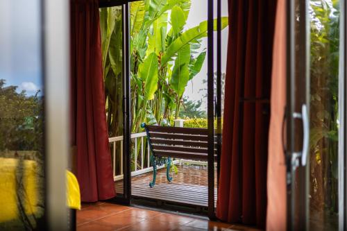 a sliding glass door with a bench on a balcony at Hotel Poas Paradise in Alajuela City