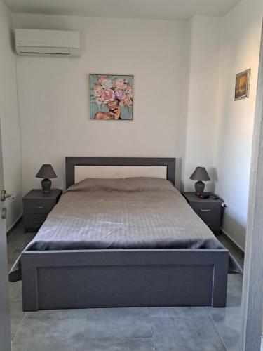 a bedroom with a bed with two nightstands and two lamps at House of Happiness in Kritinía