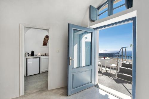 una puerta que conduce a una cocina con vistas al océano en Alba Cave Villa, en Imerovigli