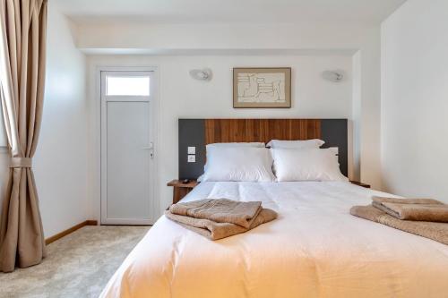 una camera da letto con un letto con due asciugamani sopra di Jolie Maison 3 à 6 pers - 35 min de Paris centre a Romainville