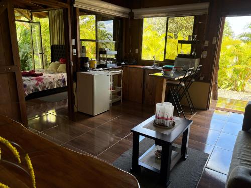 a kitchen with a refrigerator and a table in a room at Bungalow con jacuzzi YeyYe in Chachagua