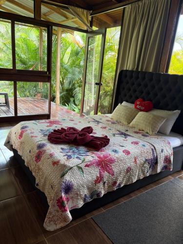 a bedroom with a bed with a flowered comforter at Bungalow con jacuzzi YeyYe in Chachagua