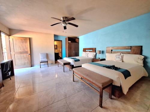 a bedroom with two beds and a ceiling fan at Hotel Agua Azul Sayulita in Sayulita
