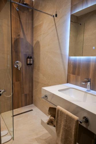 a bathroom with a sink and a shower at PineHill Hotel, Restaurant , Pool & Spa - RAZEM in Razëm