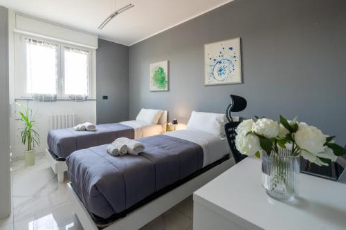 ミラノにあるNew Apartment with 4 bedroomsのベッドルーム1室(ベッド2台、花のテーブル付)
