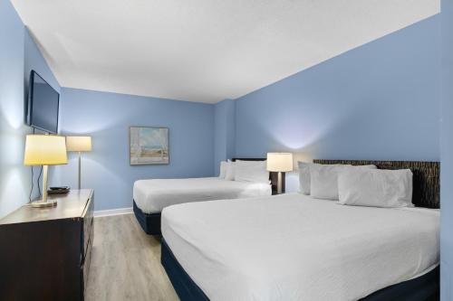 a hotel room with two beds and a flat screen tv at Seaside Resort in Myrtle Beach