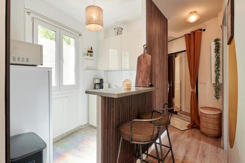 une petite cuisine avec un comptoir et deux tabourets dans l'établissement Ney - 2 Bedrooms 1 Living room, à Paris
