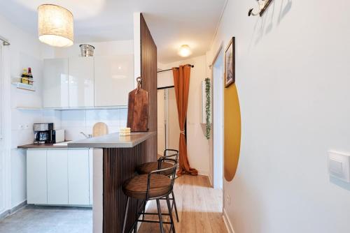 - une cuisine avec un comptoir et deux tabourets dans une pièce dans l'établissement Ney - 2 Bedrooms 1 Living room, à Paris