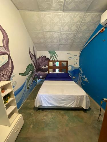 a bedroom with a bed with a painting on the ceiling at Home Beach Kristalu in Cartagena de Indias