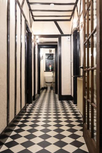 a bathroom with a toilet and a checkered floor at Criss Cross Cottage in Inverness