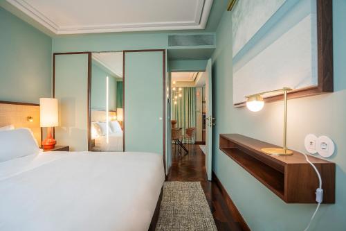 a bedroom with a bed and a desk with a mirror at Ocean Boutique Guesthouse in Matosinhos