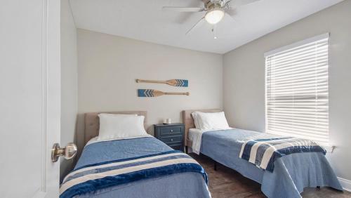 una camera da letto con due letti e un ventilatore a soffitto di Guilty Treasure a Panama City Beach