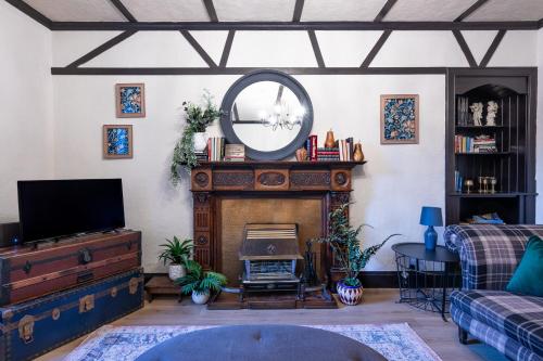 a living room with a fireplace and a mirror at Criss Cross Cottage in Inverness