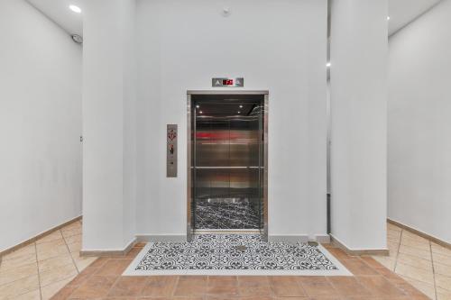 an empty refrigerator in a white room with a tile floor at Armas Hotel in San Juan