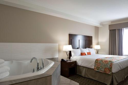 a hotel room with a bed and a bath tub at Coast Oliver Hotel in Oliver