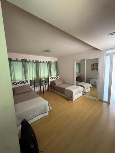 Un dormitorio grande con dos camas y un espejo. en La Divina Chapadmalal, en Chapadmalal