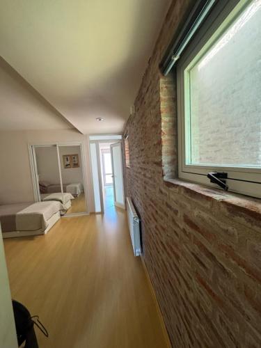 Habitación con pared de ladrillo y ventana en La Divina Chapadmalal, en Chapadmalal