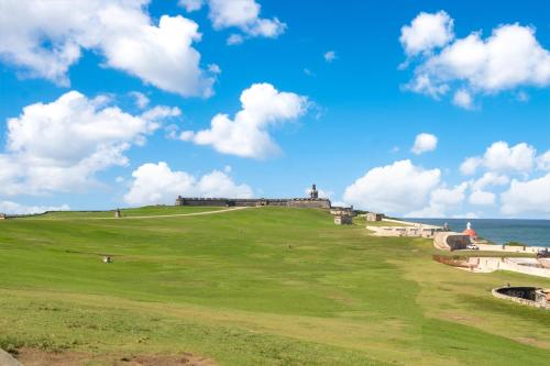a castle on a hill next to the ocean at Armas Hotel in San Juan