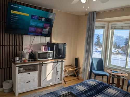 a bedroom with a bed and a tv on the wall at Salish B&B and Spa in West Kelowna