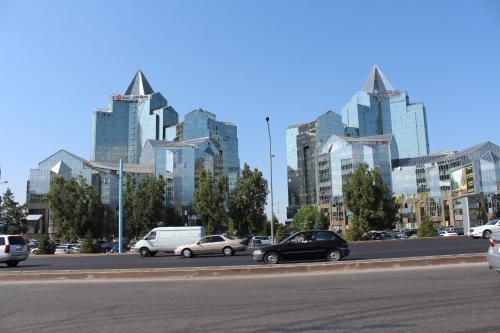 a city with cars driving down a street with tall buildings at Nadezhda Apartments in Samal in Almaty