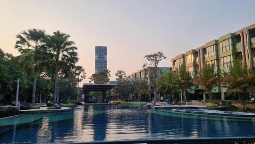a large pond in a city with palm trees and buildings at LPN Cha-am Beachfront Wifi 10 meters to beach 1BR ติดทะเล in Cha Am