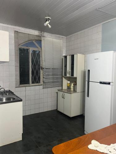 a kitchen with white appliances and a white refrigerator at Apartamento disponível para aluguel durante o Show Rural in Cascavel
