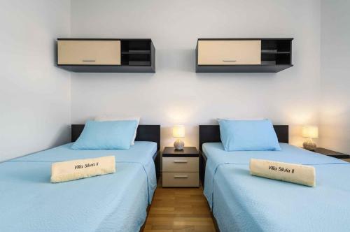 two beds in a room with blue sheets and a tv at Apartment in Mekisi kod Vizinade - Istrien 53445 in Ferenci