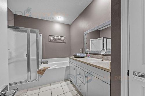 Un baño con bañera, lavabo y ducha. en Legacy Villa 1506, en Gulfport
