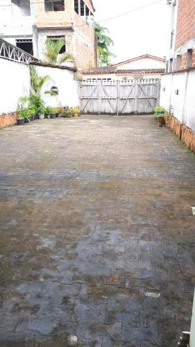 an empty courtyard with a fence and a building at Pousada Recanto do Japa in Nilo Peçanha