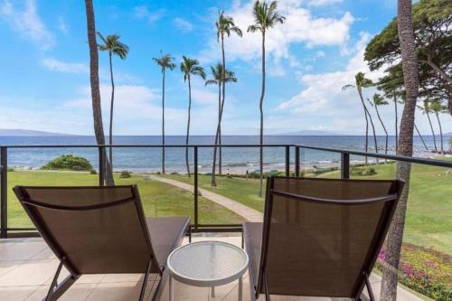 a balcony with palm trees and a view of the ocean at WAILEA ELUA, #1304 condo in Wailea