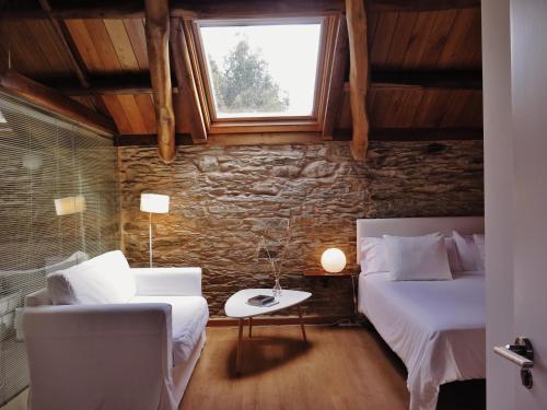una camera con due letti, un divano e una finestra di Hotel El Castaño Dormilón a Santa Marta de Ortigueira