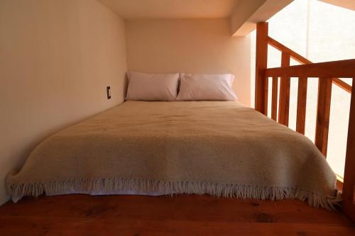 a bed in a small room with a window at Loft romántico y acogedor junto al bosque in Huasca de Ocampo