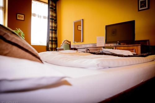 two beds in a room with a flat screen tv at Penzion Pod Kašnou in Frýdek-Místek