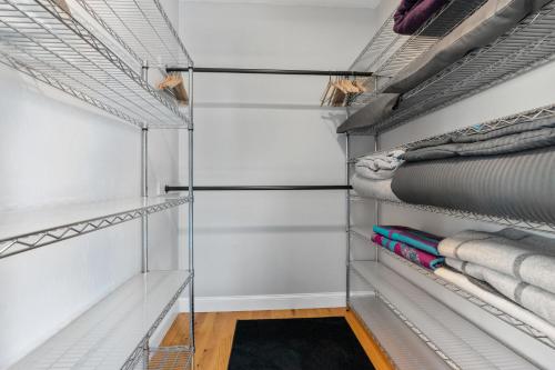 a walk in closet with white walls and glass shelves at Zen-Designed Guest Suite with PRIVATE 2-mile Trail Loop in Uxbridge