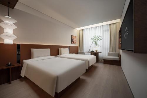 two beds in a hotel room with at SAVHE Atour Hotel on the Bund Nanjing Road Pedestrian Street -Free night snacks and afternoon tea in Shanghai
