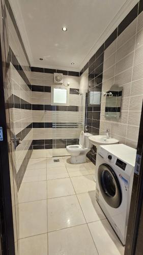 a bathroom with a washing machine and a toilet at Luxury Apartment A3 in Yanbu