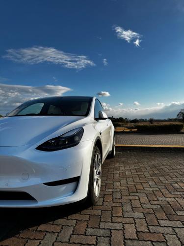 a white tesla car parked on a brick road at THE KAKU Exclusive suite & Residence in Nara
