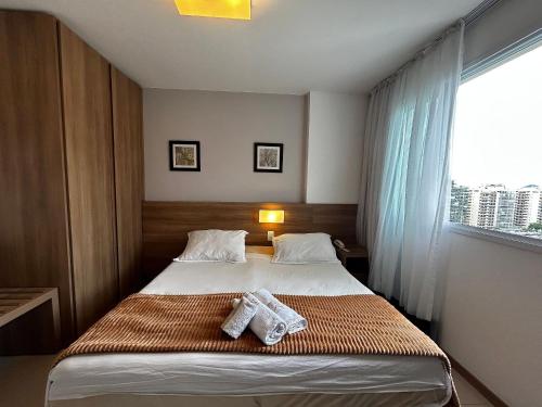 a bedroom with a bed with two towels on it at Apartamentos no Verano Stay in Rio de Janeiro
