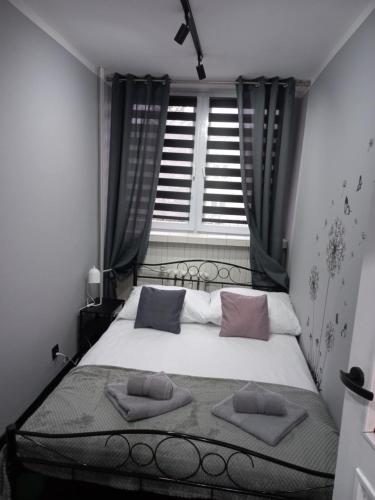a bedroom with a bed with two pillows on it at Apartament na Jasnym in Dzierżoniów