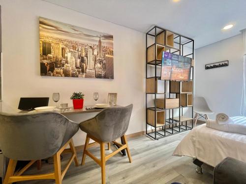 een kamer met een tafel, 2 stoelen en een bed bij 94th Street ONCE in Bogota