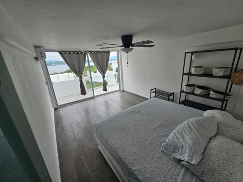 a bedroom with a bed and a ceiling fan at House Belle Vue, Tequesquitengo in Tequesquitengo