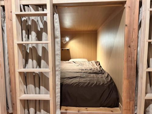 a small bedroom with a bed in a bunk room at Guest House & Cafe Yamaboushi in Tsushima