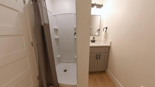 a bathroom with a sink and a toilet and a mirror at Pet Friendly Studio Next To Food Pavilion in Coeur d'Alene