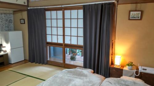 a bedroom with a bed and a large window at 民泊haruna in Yufuin