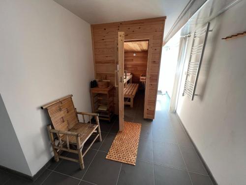 a hallway with a chair and a table in a room at Spacious Villa with Sauna in Érezée