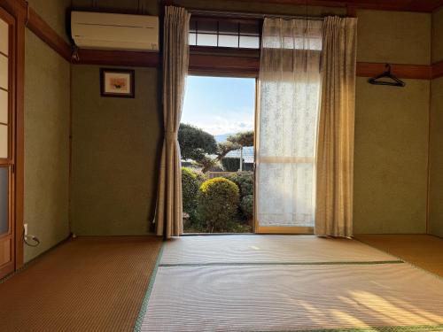 Habitación vacía con ventana grande con vistas en いしづち安藤家, en Saijo