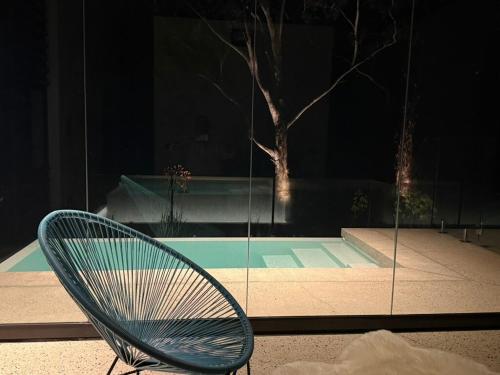 a chair sitting in front of a pool at night at Huzzah! in Theresa Park