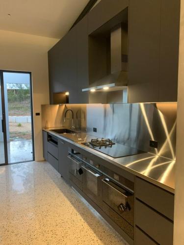 a kitchen with a sink and a stove top oven at Huzzah! in Theresa Park